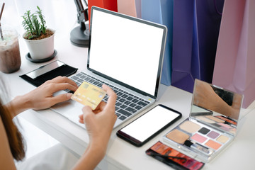 Mockup image of beautiful woman holding credit card enjoying in shopping website online with smartphone and laptop, mockup concept