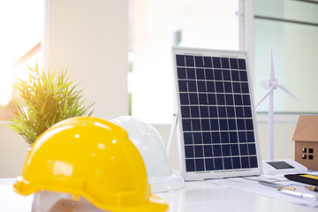 Desk of Architectural working solar panel home project in construction site,With drawing equipment concept.