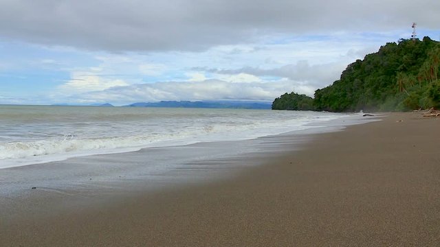 Time lapse de playa en el mar pac&iacute;fico, con monta&ntilde;as azules y nubes en movimiento