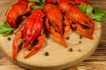 Boiled crayfish on cutting board on wooden table