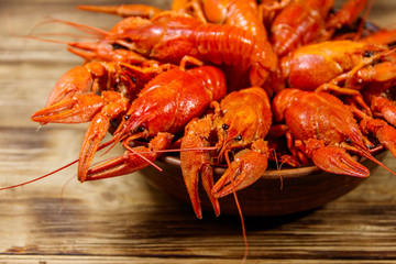 Boiled crayfish in plate on wooden table