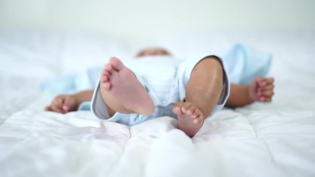 little cheerful baby move leg on a bed