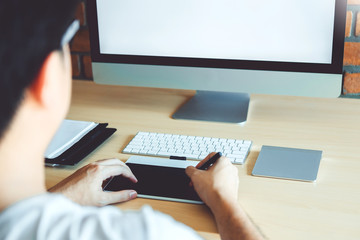 Blank screen of Graphic designer drawing on graphics tablet at workplace