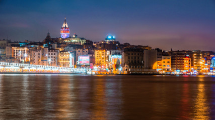 Night view of Istanbul cityscape Galata Tower with floating tourist boats in Bosphorus ,Istanbul Turkey