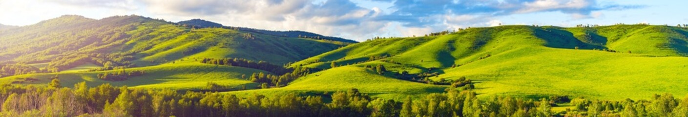 Mountain Slopes, Trees and Meadows, Vibrant Summer Sunset with Warm Sun Flare through the Clouds. Altai Mountains, Kazakhstan.