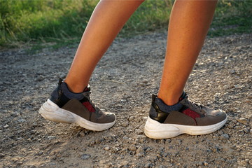 Athlete runner feet running in nature, closeup on shoe. Woman fitness jogging, active lifestyle concept