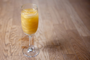 Glass with a yellow cocktail on the bar counter.