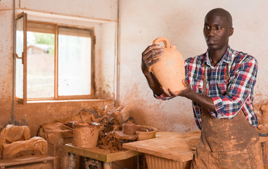 Potter checking quality of ceramic objects