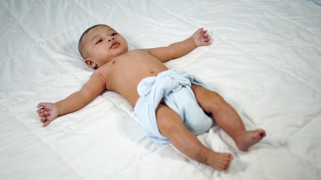 slow-motion of little cheerful baby on a bed