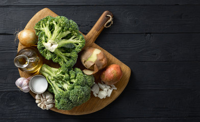 Raw ingredients for cooking cream broccoli soup on a wooden background