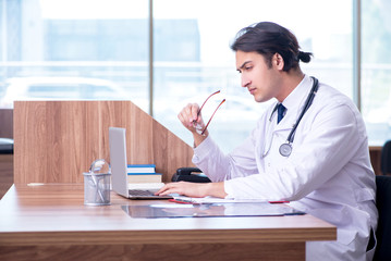 Young handsome doctor working in the clinic