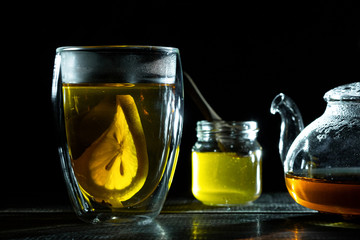 hot fresh black tea with slice lemon in transparent thermomug and honey. Glass teapot. Tea ceremony