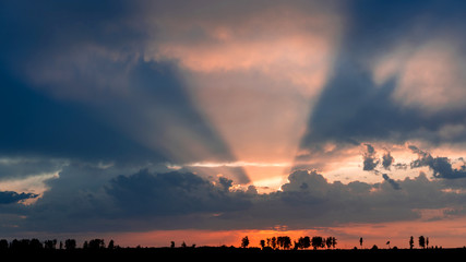 rays sunset through rain clouds. Epic landscape photography.