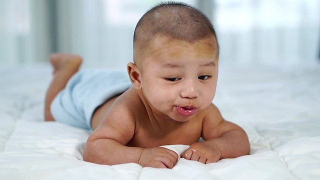 slow-motion of happy baby on a bed at home