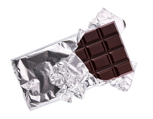 Chocolate bar in opened  foil isolated on white background. Dark chocolate bar half in foil isolated on white background, top view.