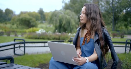 Girl freelancer working with a laptop in the city Park in the afternoon