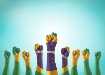 Afwasbaar behang Brazilië Vlag van Brazilië op handen van mensen met gebalde vuisten die opstaan voor de viering van de nationale feestdag van de arbeid en sterk blijven voor Braziliaanse macht geïsoleerd op blauwe hemelachtergrond (uitknippad)