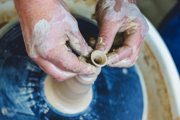A potter makes a jug on a potter's wheel, top view_