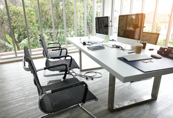 Desks with PCs in bright and modern open space office