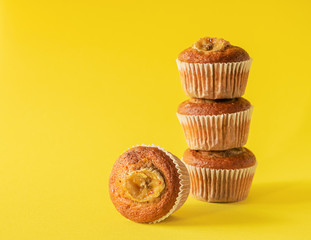 Stack of banana muffins on a yellow background. Healthy vegan dessert. Horizontal frame. Copy space.