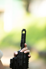 girl holds the barrel of an assault rifle