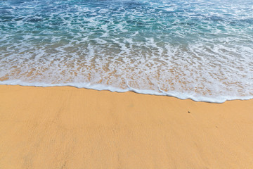 Fototapeta na wymiar Blue ocean wave with foam on sandy beach. Beach background.