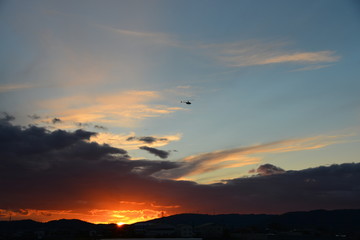 夕陽の空に飛ぶヘリコプターです。