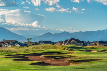 Golf course with houses and mountain in the background viewed on a sunny day