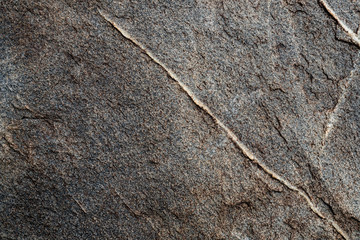 The texture of the stone overgrown with moss. Background image of a boulder