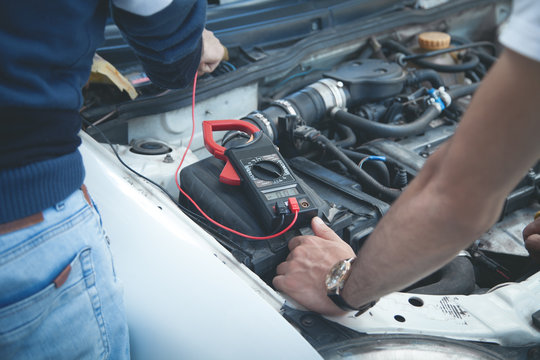 Mechanic With A Multimeter Testing Car Engine. Car Service