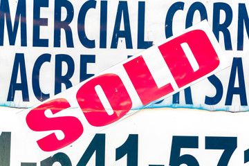 Naklejka premium Close up of a Sold sticker on a real estate for sale sign viewed on a sunny day