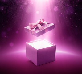 Purple color open gift box with ribbon on glittering background