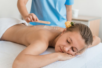health, beauty, resort and relaxation concept - beautiful woman with closed eyes in Spa salon getting massage