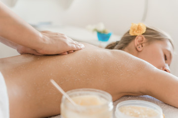 Young woman relaxing with hand massage at beauty Spa. body scrub, skin cleansing