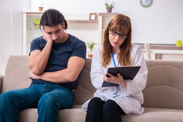 Young male patient discussing with female psychologist personal