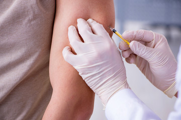Male patient visitng doctor for shot inoculation