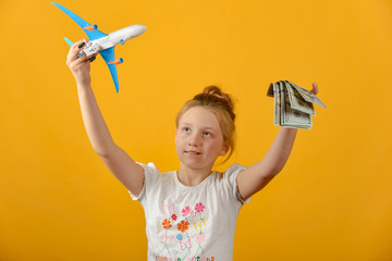 Girl holding airplane and money in her hands, concept of vacation and travel.