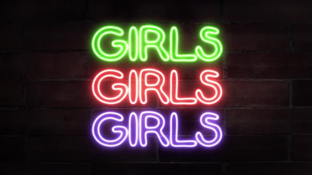 A flickering neon sign (intermittently turning on and off) with the text Girls, hanging from a brick wall, in three different colors: green, red, purple (violet).