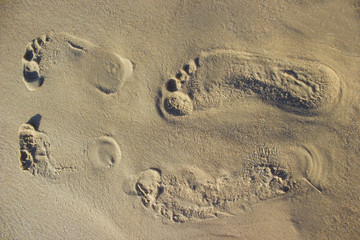 Footprints two people in the sand sunrise background sea