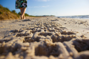 Footprint in sand car tire quadro cycle at sunrise beach, girl