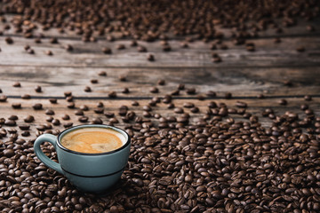 Blue cup of coffee espresso with beans on brown wooden table