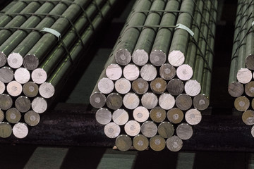 Round steel section rolling profile in stacked. Warehouse of metal products.