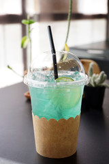 Mint Lemon Soda - A plastic glass of Iced blue hawaii soda with lemonade on blurred background, Summer Cocktail or Tropical Mocktail, , Perfect drink for summer time.