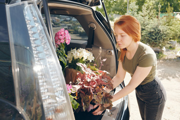 Redhead florist putting flowers in trunk