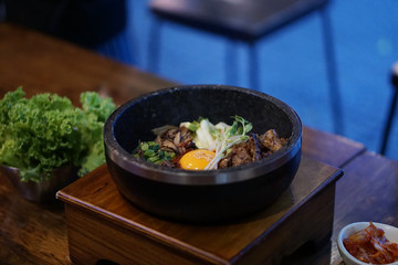 Dolsot bibimbap - Korean mixed rice, Include steamed rice, vegetables, pork and fried egg on top, served in a hot stone pot, Dolsot means stone pot in Korean.