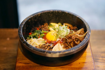 Dolsot bibimbap - Korean mixed rice, Include steamed rice, vegetables, pork and fried egg on top, served in a hot stone pot, Dolsot means stone pot in Korean.