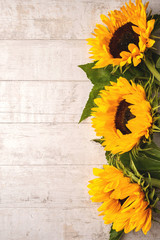 Flowers composition of yellow sunflowers on a white wooden background. Top view, copy space. Floral texture background.
