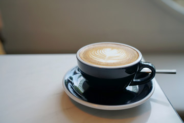 Hot Latte - A cup of coffee with milk and beautiful leaf pattern latte art on marble table and blurred background, Perfect for breakfast time.