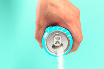 hand holding soda can pouring a crazy amount of sugar in metaphor of sugar content of a refresh...