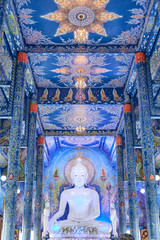 interior of the blue temple, in thailand with a big bright white buddha, vertical photo